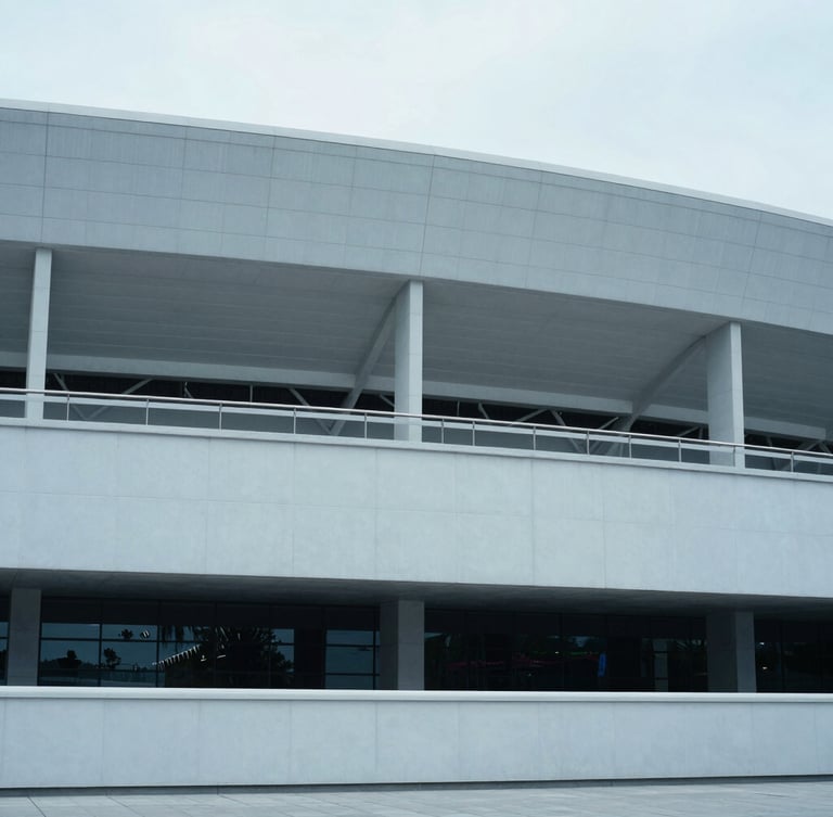 Wide-angle architectural view of a modern stadium exterior, clean lines, cool diffused daylight, desaturated blue tones, 35mm