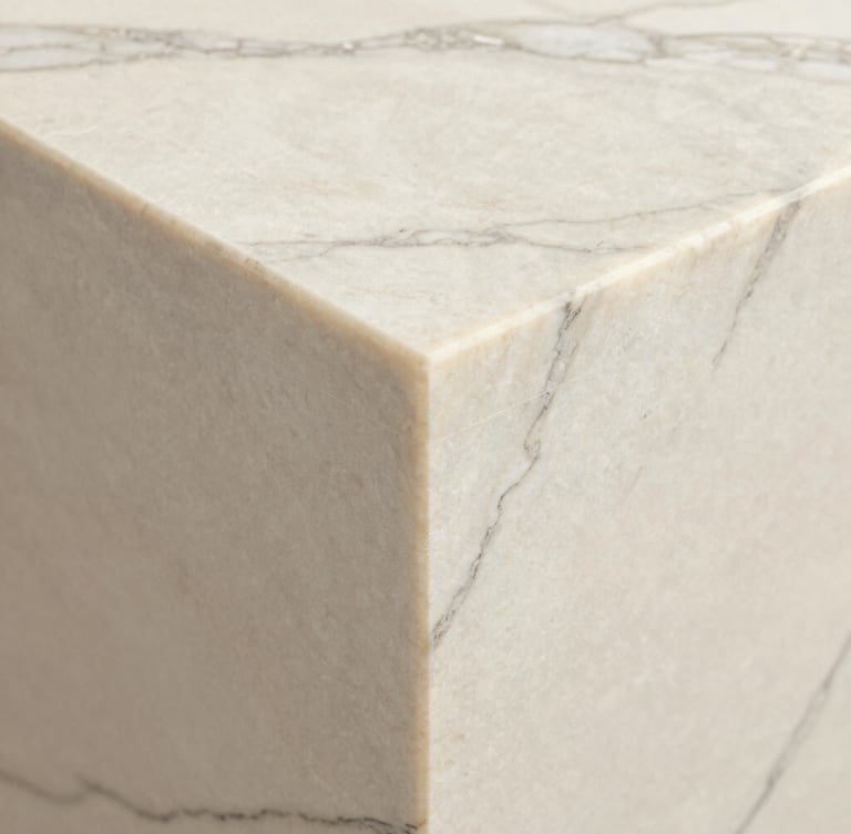 Close-up detail of a mitered edge transition on a Calacatta marble slab, perfect grout-line alignment, soft natural side lighting, architectural detail