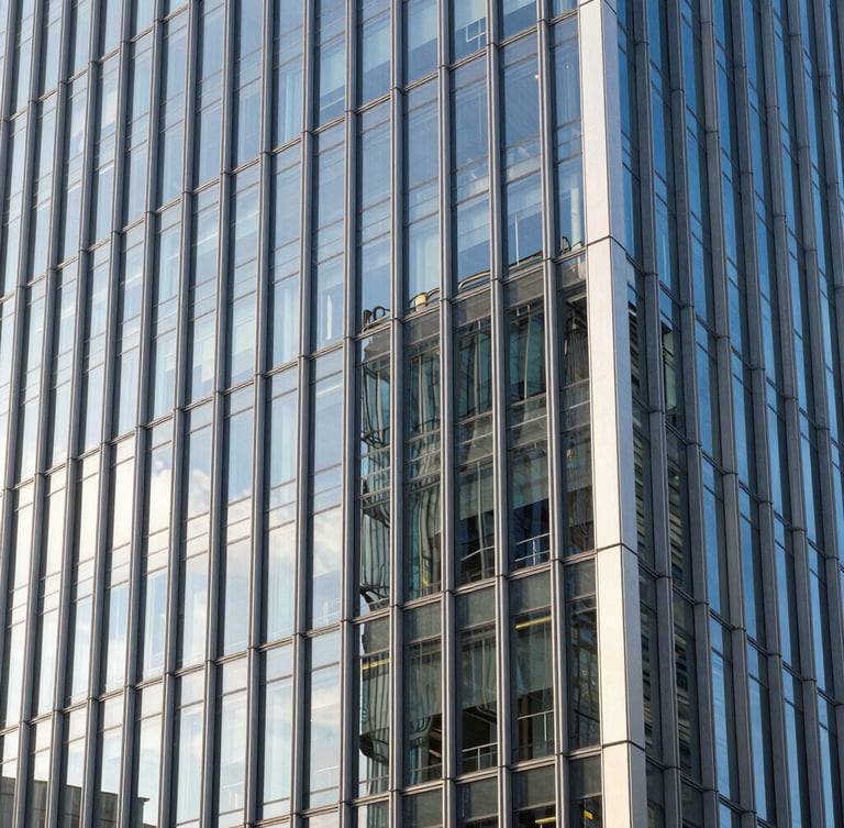 Architectural close-up of a modern European financial district building with clean glass facade reflecting bright morning sunlight.