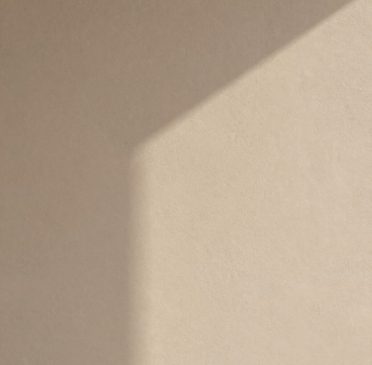 Minimalist abstract photography of warm plaster texture with soft architectural shadows, sand and neutral tones, diffused natural light, clean balanced composition, 35mm