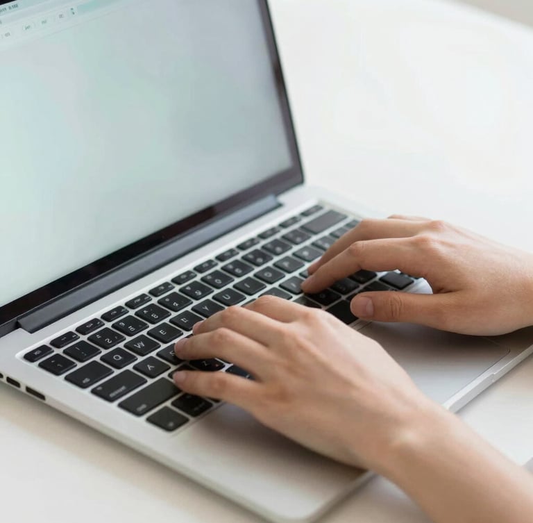 Close-up of hands typing on a laptop keyboard, clean bright digital workspace, soft daylight, sharp focus on modern interface