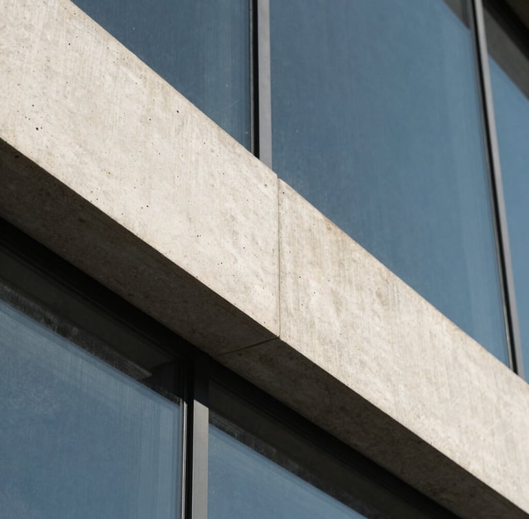 Macro architectural close-up of sharp concrete angles and glass under cool natural daylight, high-contrast slate shadows, 35mm