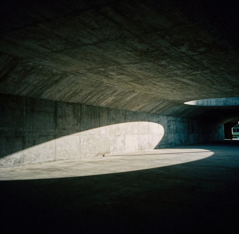 Dramatic low-key editorial photography of an empty architectural concrete stadium tunnel, cinematic shadows, deep green tones, 35mm film grain