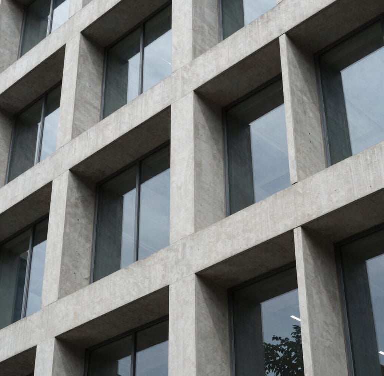 A highly structured modern office facade in Bengaluru, crisp geometric concrete lines, sharp daylight reflection, clean architectural detail.
