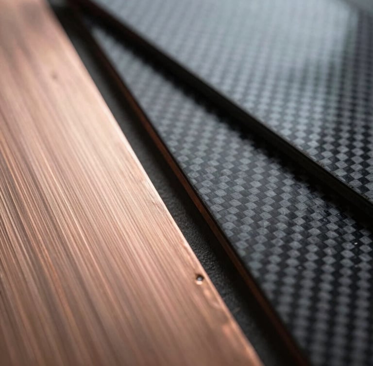 Extreme macro photograph of high-contrast raw material swatches, displaying brushed copper plates and textured carbon fiber sheets, overcast industrial daylight.