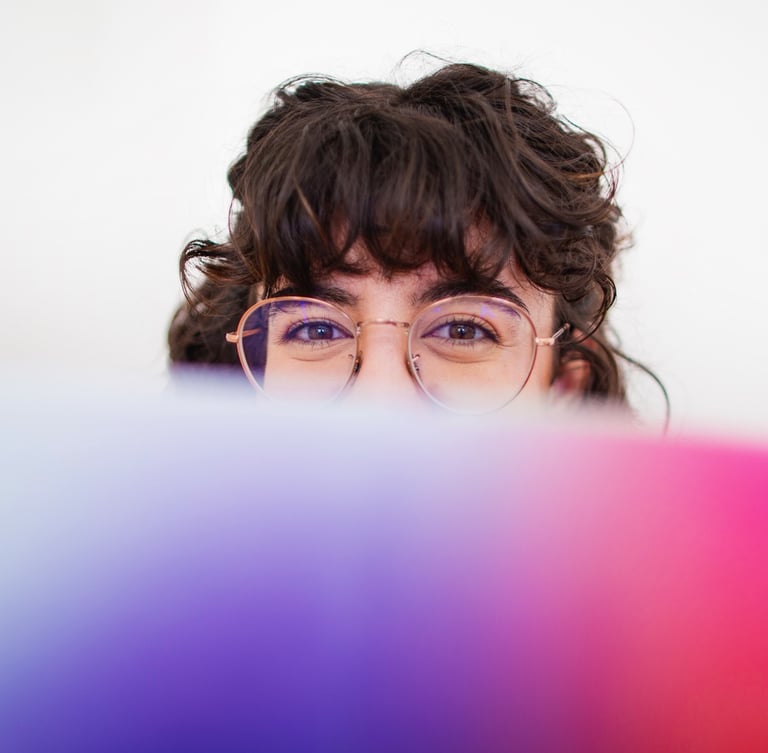 Fotografía de Blanca trabajando en su estudio tapada con un libro sobre paletas de color