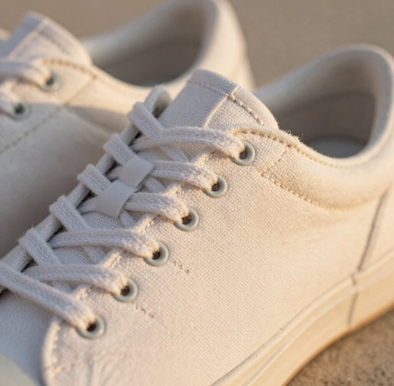 Close-up of premium breathable canvas and soft stitching on a shoe, warm golden-hour sunlight, shallow depth of field, 35mm.