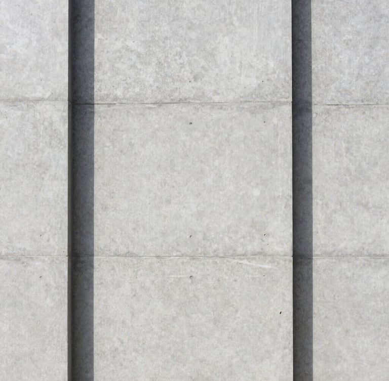Clean straight-on architectural photography of a modern concrete facade with sharp shadows, bright diffused daylight, neutral gray tones, 35mm.