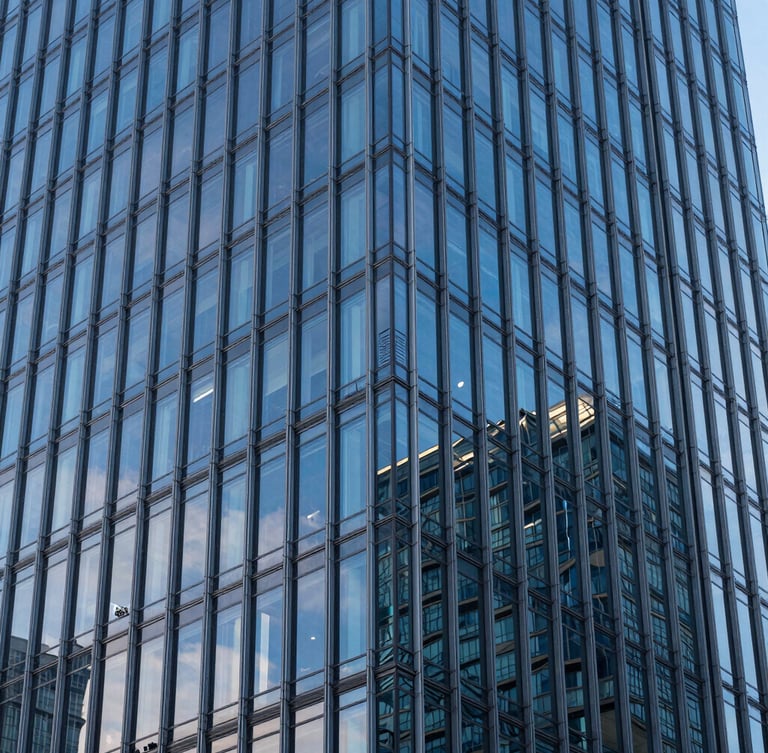 High-angle architectural detail of a modern steel and glass skyscraper facade, cool blue-hour lighting, crisp reflections.