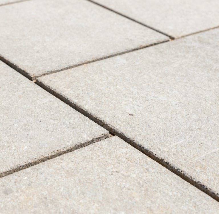 Close-up macro shot of crisp, freshly repointed mortar joints between clean sandstone patio slabs, bright natural daylight, sharp focus on the texture of the stone