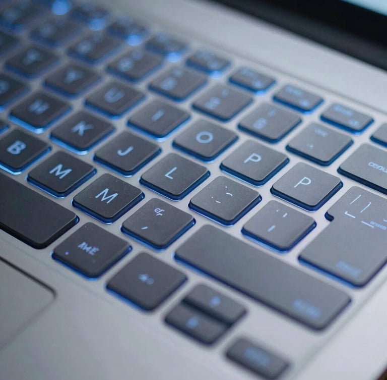 Close-up macro shot of a modern laptop keyboard, cool blue backlighting, sharp focus on the keys, subtle digital shield overlay, portrait aspect