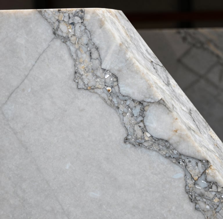 Macro shot of a premium white quartzite slab with dramatic grey veins, hard directional lighting highlighting the crystalline polished texture, architectural framing