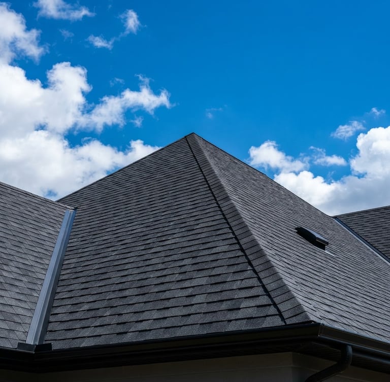 Low-angle architectural shot of a secure, newly shingled roofline against a bright blue sky, daylight emphasizing clean shingle alignment, 35mm
