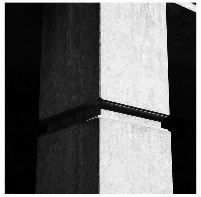 Stark high-contrast black and white architectural detail of a brutalist London concrete column, razor-sharp directional sunlight, deep shadows, 35mm film