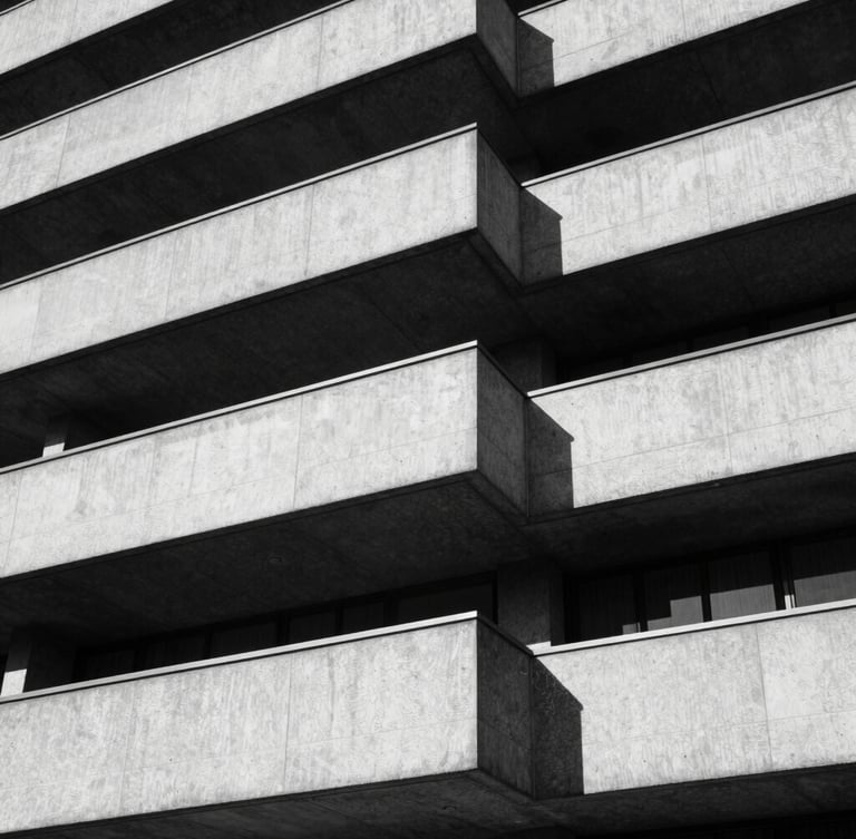 Stark black and white architectural detail of concrete London brutalist building, hard directional sunlight, deep sharp shadows, 35mm film