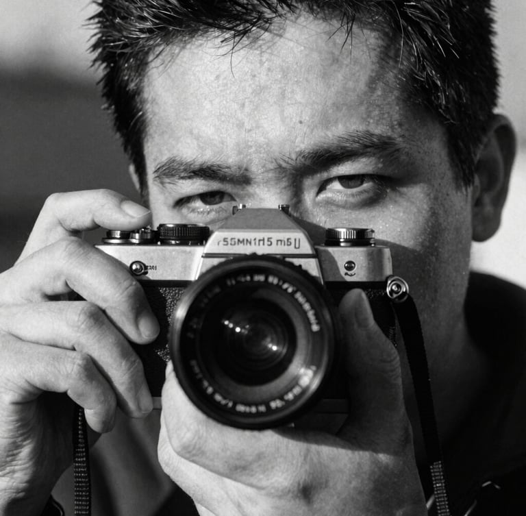 Extreme close-up portrait of a photographer holding a 35mm camera, harsh direct sunlight casting deep shadows across half the face, heavy film grain, gritty black and white photography, 35mm tri-x film style