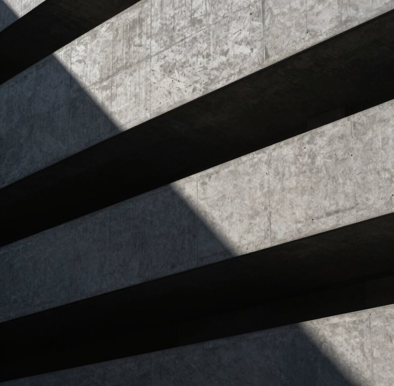 Low-key, high-contrast architectural crop of a modern concrete facade with sharp geometric shadows, cool tones, clean lines.