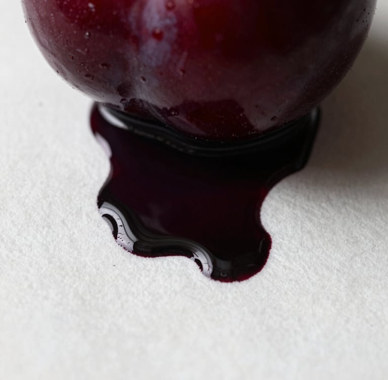 Extreme macro photograph of dark plum ink bleeding into heavy white cotton paper, high-contrast chiaroscuro lighting, visible paper fibers and rich paint ridges.