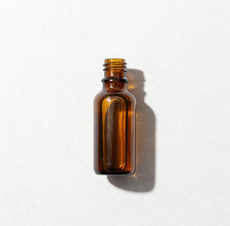 Overhead laboratory-style flat lay of a single amber glass bottle on a clean white stone surface, bright high-key studio light, sharp defined shadows, crisp details, 50mm lens