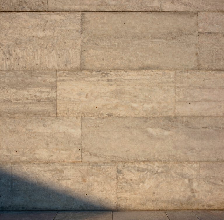 Straight-on architectural elevation of a concrete and raw timber wall, soft golden hour light casting long shadows across textured travertine slabs, medium format film style.