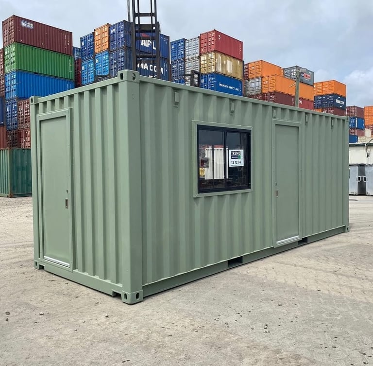 Modified light green shipping container converted into a portable office or site shed in a storage yard.