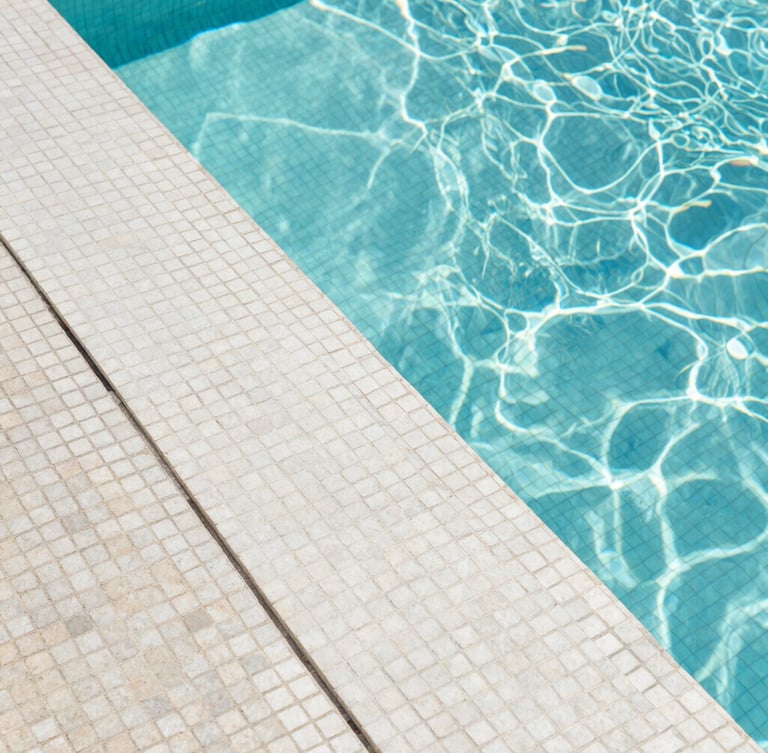 Macro architectural photograph of perfectly aligned Italian mosaic tiles under crystal clear water, sharp geometric pool edge, bright Mediterranean daylight