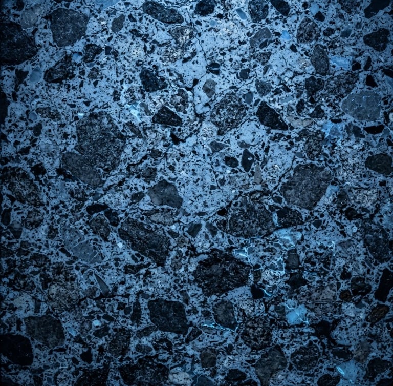 Extreme close-up of cured C80/95 high-strength concrete petrographic cross-section, industrial diagnostic blue light, high contrast