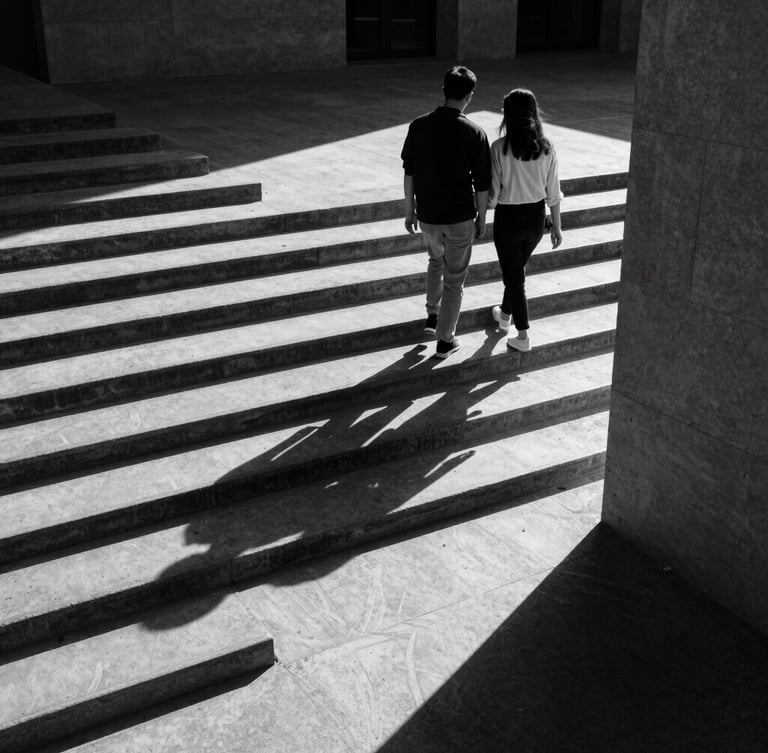 A high-contrast medium-format black and white photograph of a couple walking down a concrete staircase in harsh sunlight, long shadows casting geometric patterns, architectural framing, candid movement.