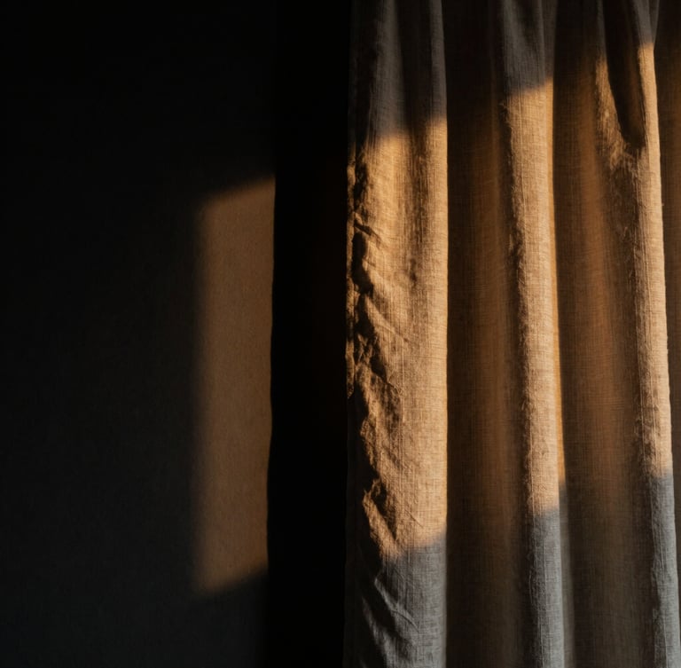 Dramatic close-up of heavy linen curtain catching low-angle side light, casting deep shadows on a matte black wall, moody editorial interior photography, 35mm lens