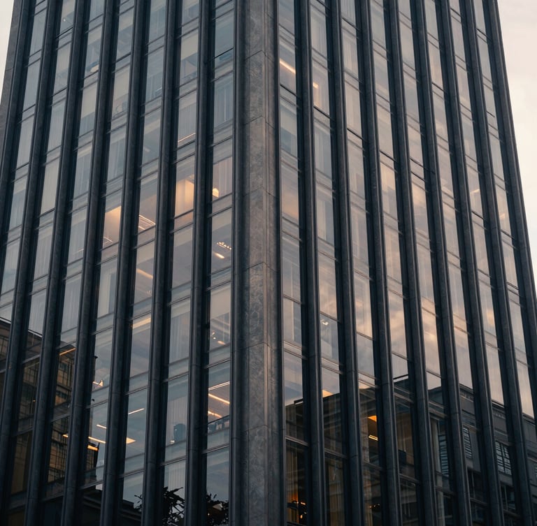 Architectural wide shot of a modern financial capital skyscraper facade, soft diffused window light, muted navy tones, 35mm.