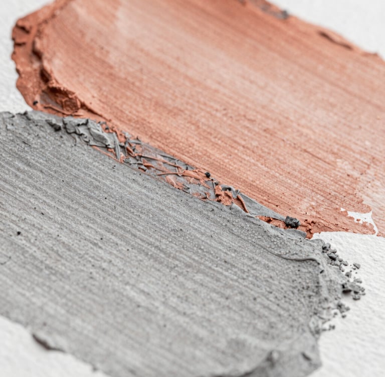 Macro close-up of textured paint strokes on heavy watercolor paper, showcasing layered terracotta and ash gray pigments under soft side-lighting