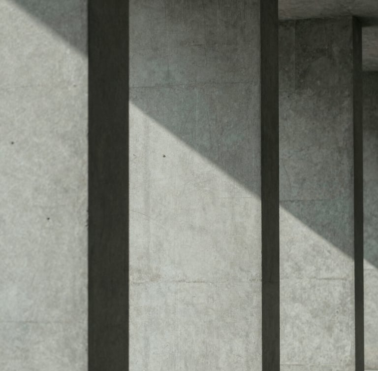 Minimalist editorial photography of architectural concrete columns casting parallel diagonal shadows, cool diffused daylight, 35mm