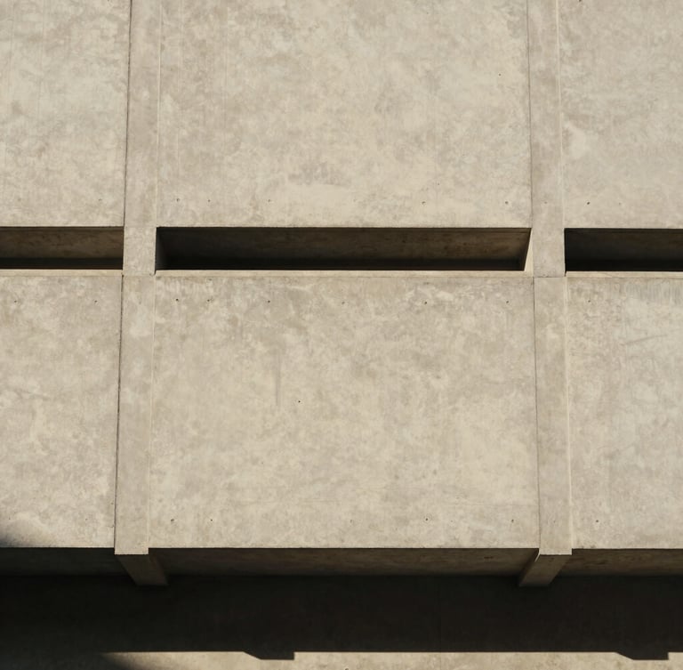 Straight-on architectural detail of a concrete facade with clean geometric lines, soft natural daylight casting subtle shadows, warm editorial style, 35mm
