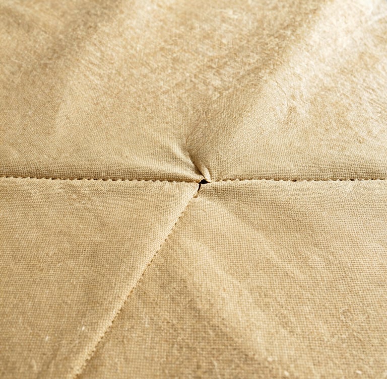 Macro photography of heavy-duty 1100 g/m² PVC-coated polyester fabric texture, showing the rugged weave and industrial heat-sealed seams.