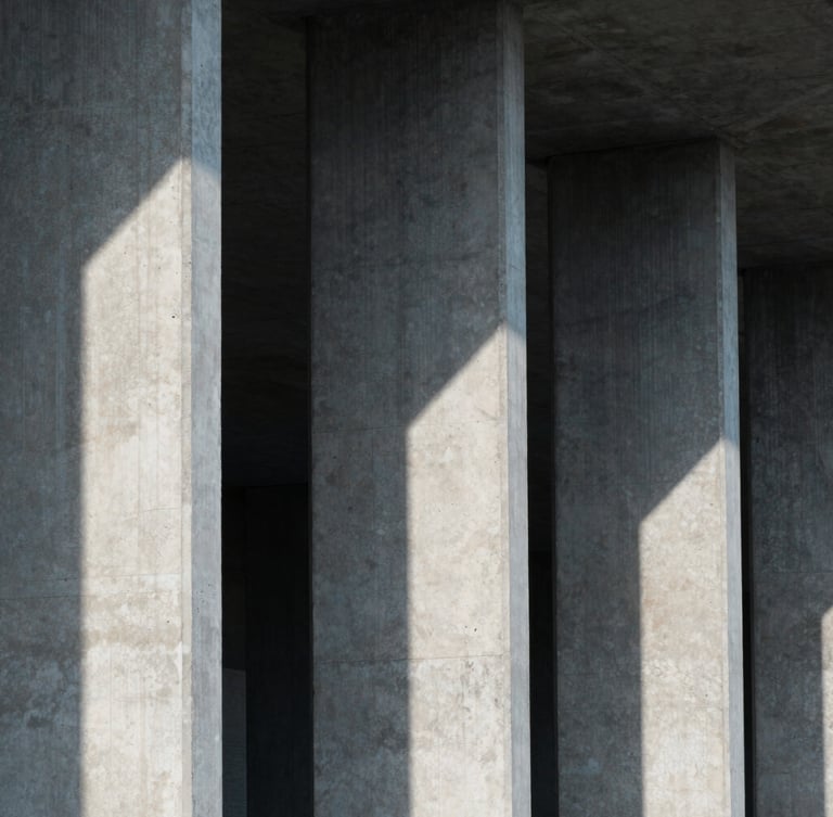A close-up architectural shot of concrete pillars and sharp geometric shadows under cool, diffused daylight, emphasizing structural integrity.