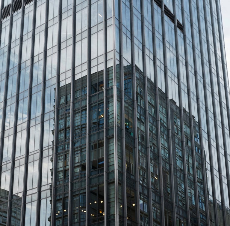 Sleek modern high-rise glass facade reflecting cool daylight, sharp architectural shadows, 35mm photography