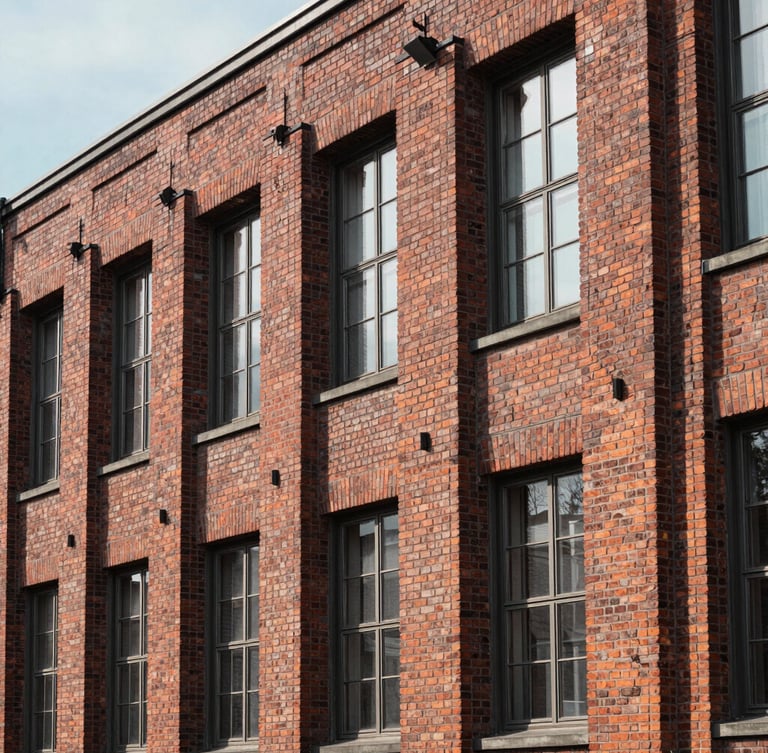 Architectural detail of a classic brick factory facade in northern Germany, clean lines, soft natural daylight, deep realistic shadows.