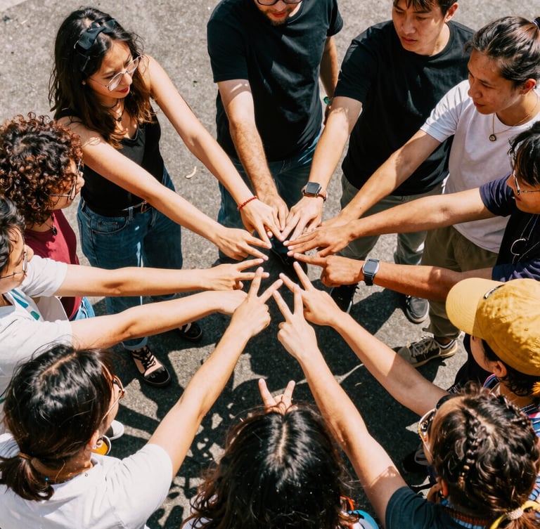 A vibrant group photo of creative professionals in a huddle, high-contrast natural daylight, energetic saturated colors, 35mm film feel