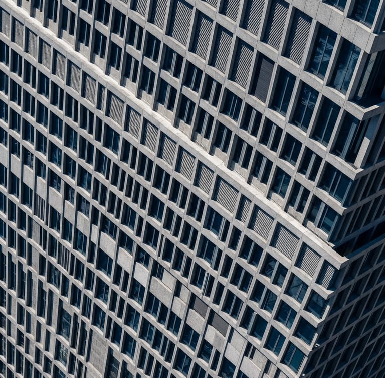 High-angle architectural photography of a modern corporate building facade, sharp daylight, deep blue shadows, concrete gray texture, technical grid overlay, 35mm