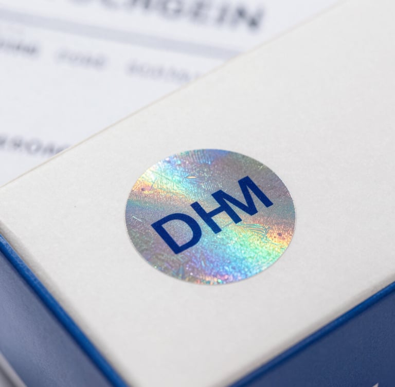 Close-up macro shot of a genuine OEM holographic seal on a product box, with official looking paperwork partially visible in the background. Bright, neutral commercial lighting.