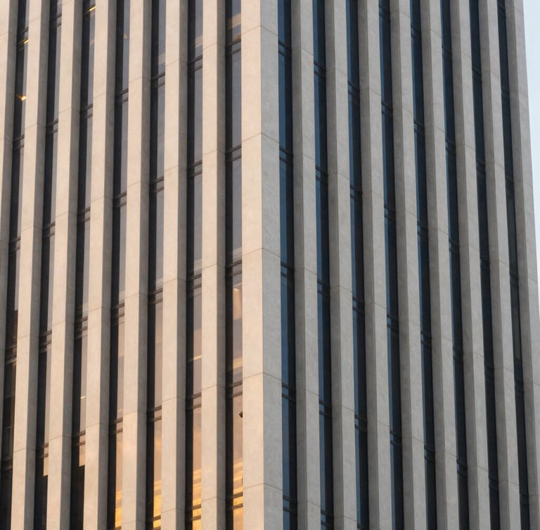 Architectural detail of modern JAFZA office tower facade in Dubai, clean vertical lines, soft golden hour window reflections, off-center composition.
