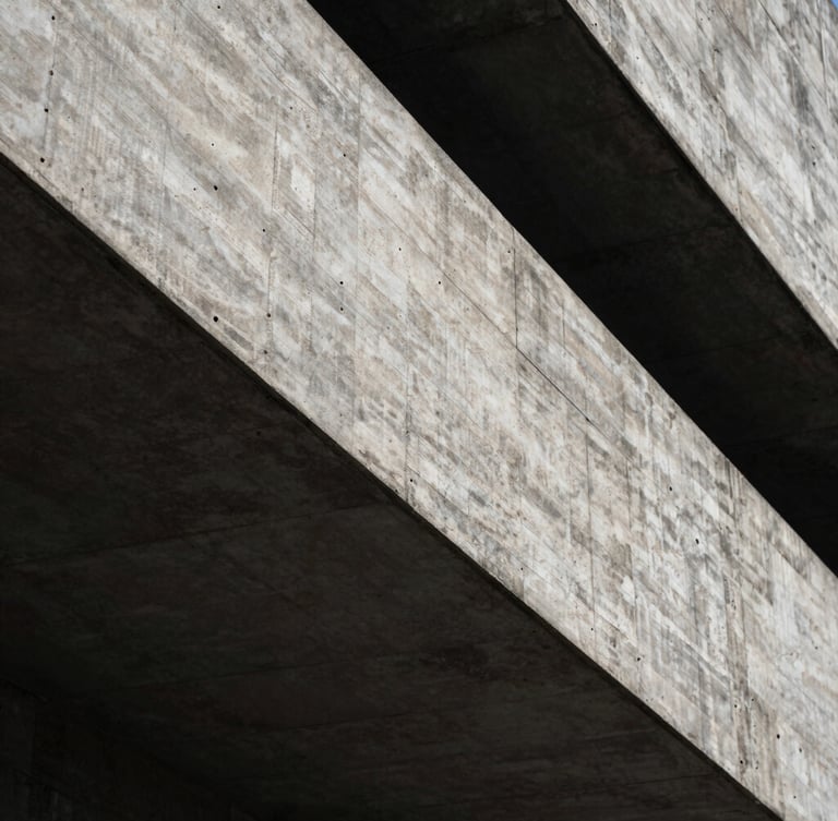 Abstract close-up of a monolithic brutalist concrete structure with deep shadows and sharp geometric lines, low-key dramatic side-lighting.