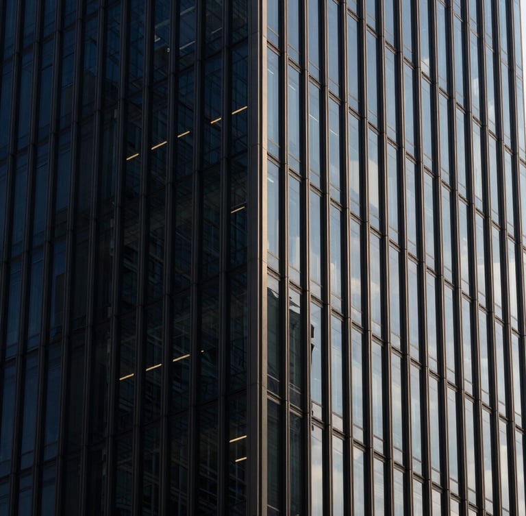Macro architectural detail of a modern steel and glass skyscraper corner, sharp high-contrast daylight casting dramatic geometric shadows, deep navy tones, minimalist editorial photography