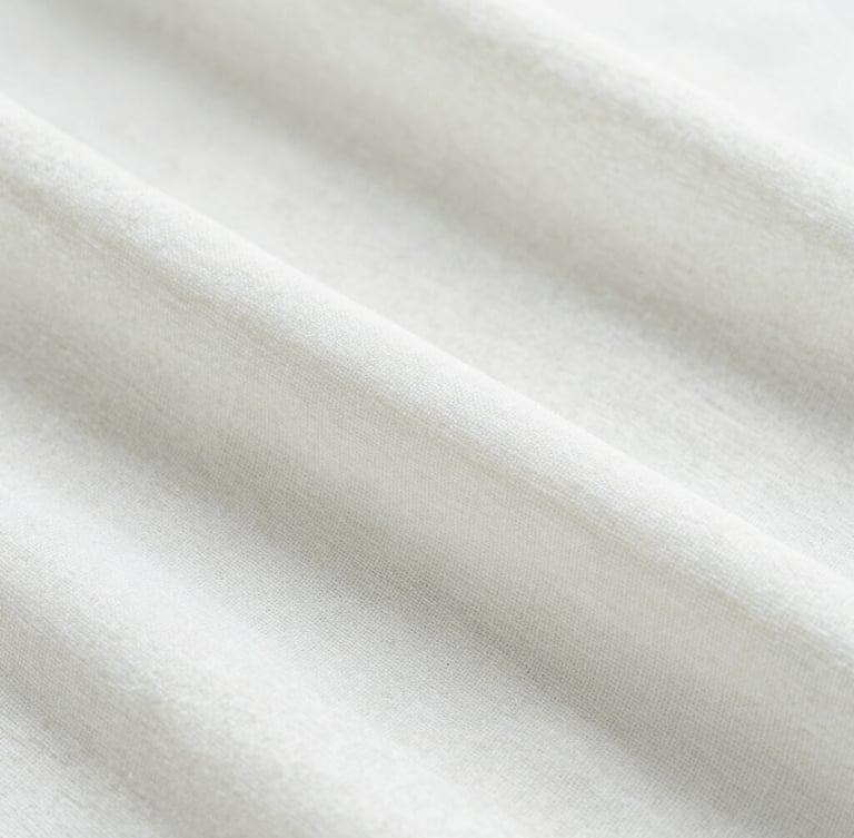Minimalist macro photography of soft white linen fabric texture under gentle morning sunlight, clean and fresh atmosphere