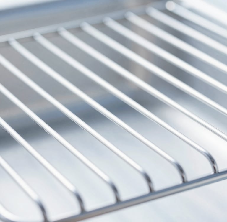 Macro detail shot of a gleaming, professional deep-cleaned oven rack, bright high-key natural daylight, sharp focus