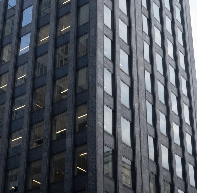 Editorial architectural detail of modern financial district skyscraper in New York, cool natural window light, muted navy and slate tones, shallow depth of field, 35mm