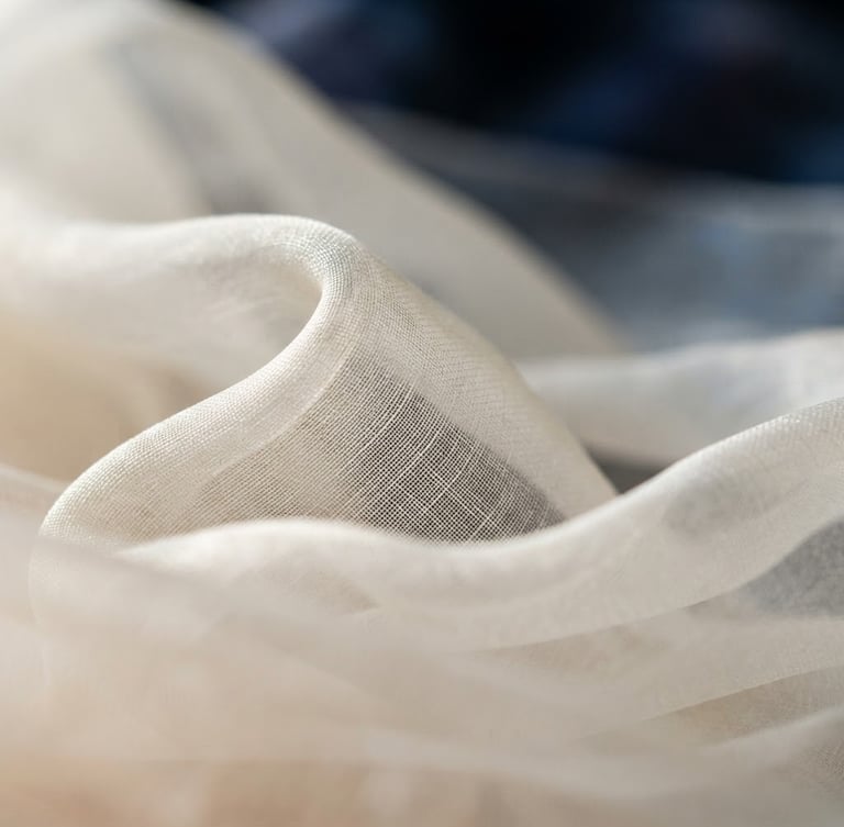 Macro close-up of luxurious Turkish organza fabric in ivory, showing delicate weave and soft drape under diffused side-lighting, shallow depth of field.