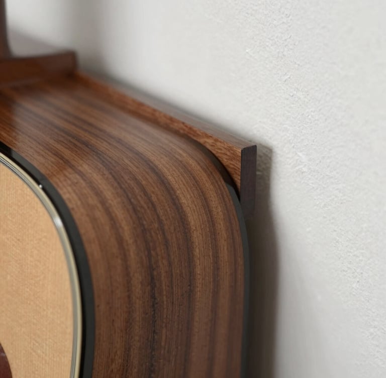 Macro close-up of custom walnut acoustic slats meeting a clean plaster wall, soft side lighting highlighting the tactile wood grain and precise alignment.