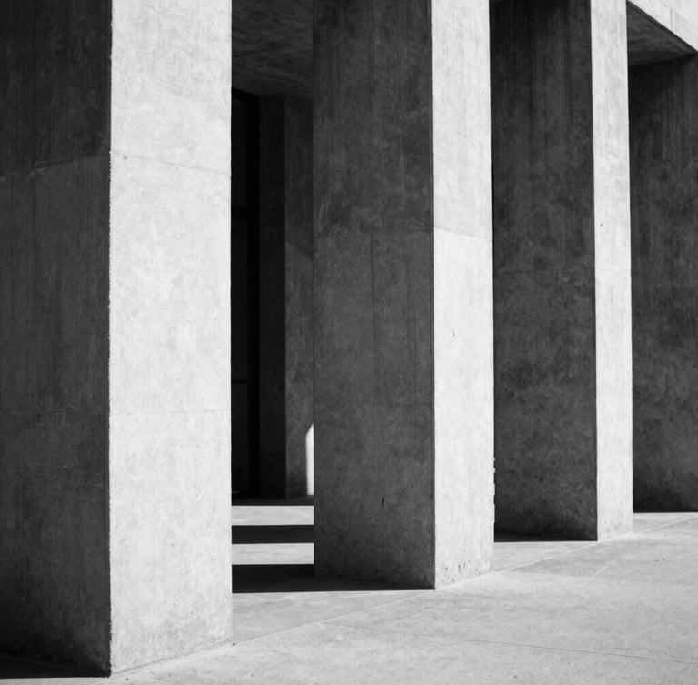 Stark black and white architectural photography, harsh direct sunlight hitting concrete pillars, deep geometric shadows, minimalist composition, 35mm film