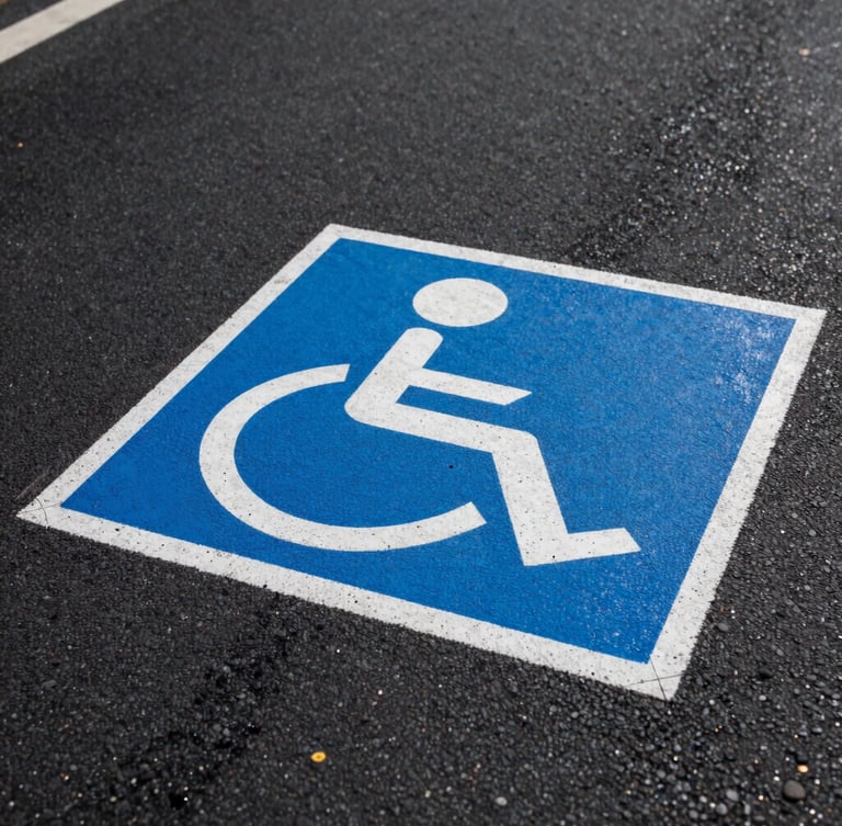 Low-angle perspective shot of a freshly painted blue and white ADA handicap stencil on dark, textured asphalt, crisp wet edges, sharp morning light